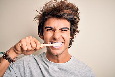 handsome young man brushing his white teeth