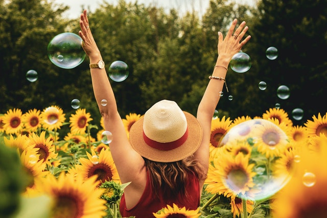 pexels-andre-furtado-1263986 happy lady wearing a sun hat in a field of sunflowers - she's health because she's invested in FlexTerm from Everest